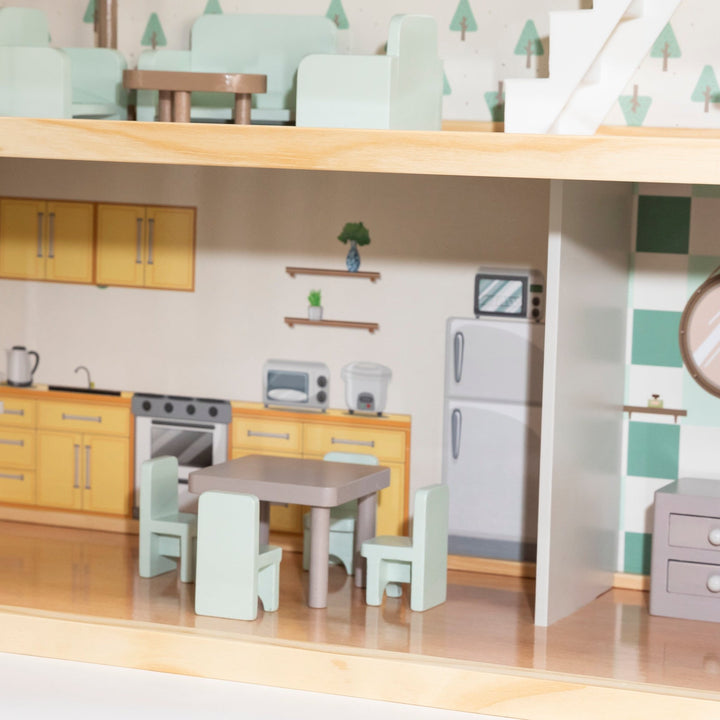 Interior de una casa de muñecas con una cocina y un comedor. Una mesa marrón con dos sillas verde menta.