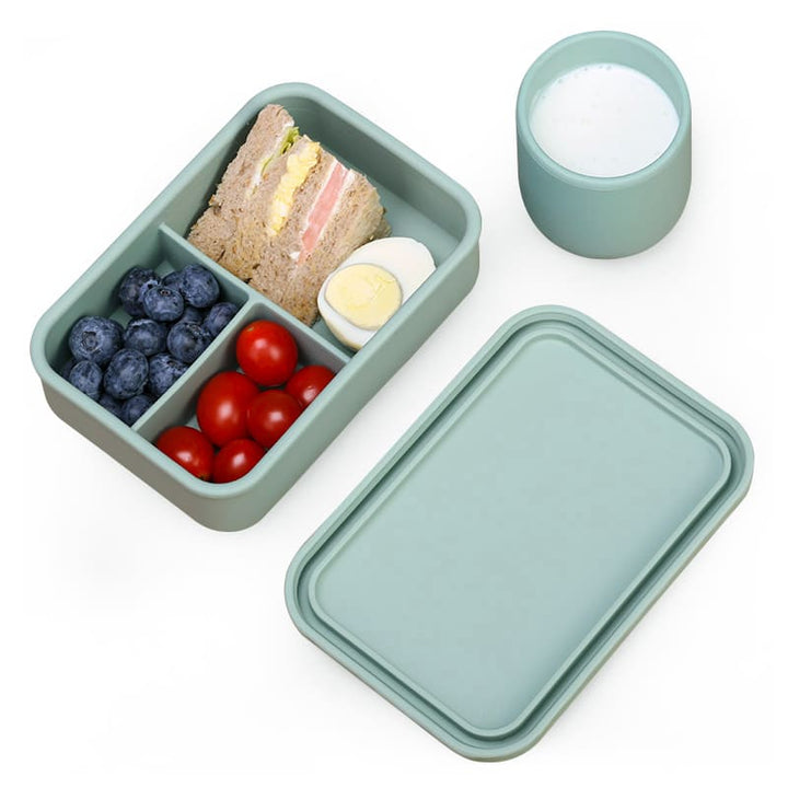 Lonchera de silicona verde menta con tres divisiones y vaso a juego. Tupper moderno para colaciones
