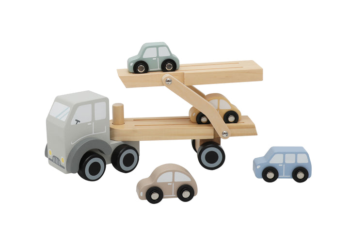 Niño jugando con camión portaautos de madera de Roots Toys