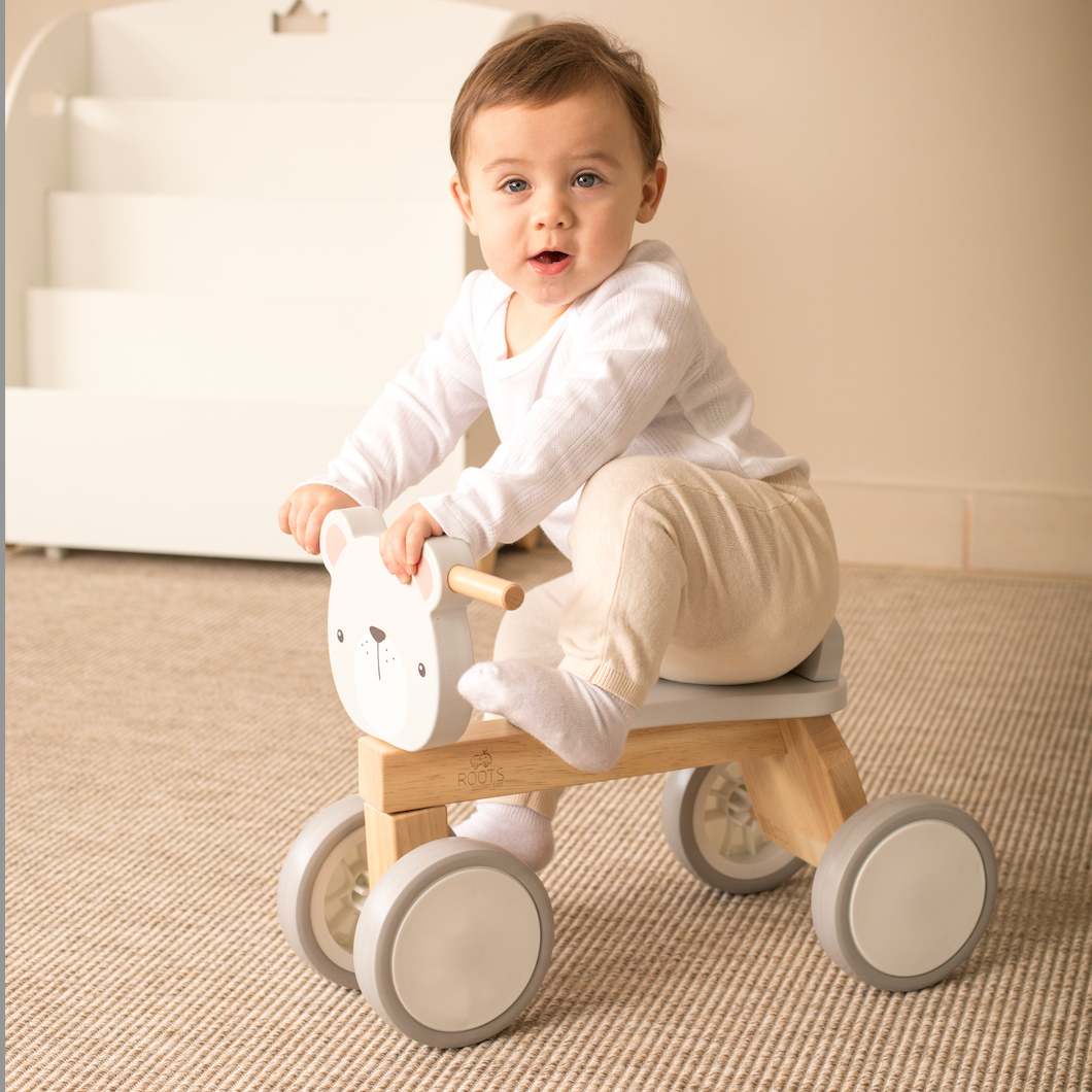 Niño usando andador de madera tipo bicicleta de equilibrio para potenciar la motricidad global