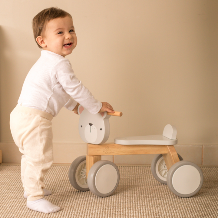 Niño de pie apoyado en correpasillos de madera oso, ideal para aprender a caminar