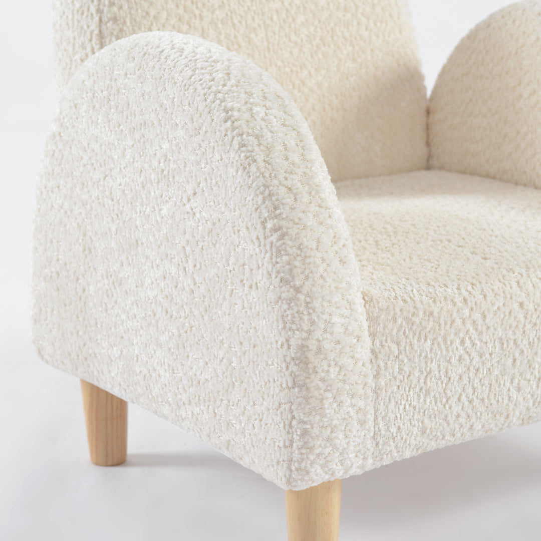 Detalle de apoyabrazos acolchado en tela blanca de sillón infantil, y diseño nórdico