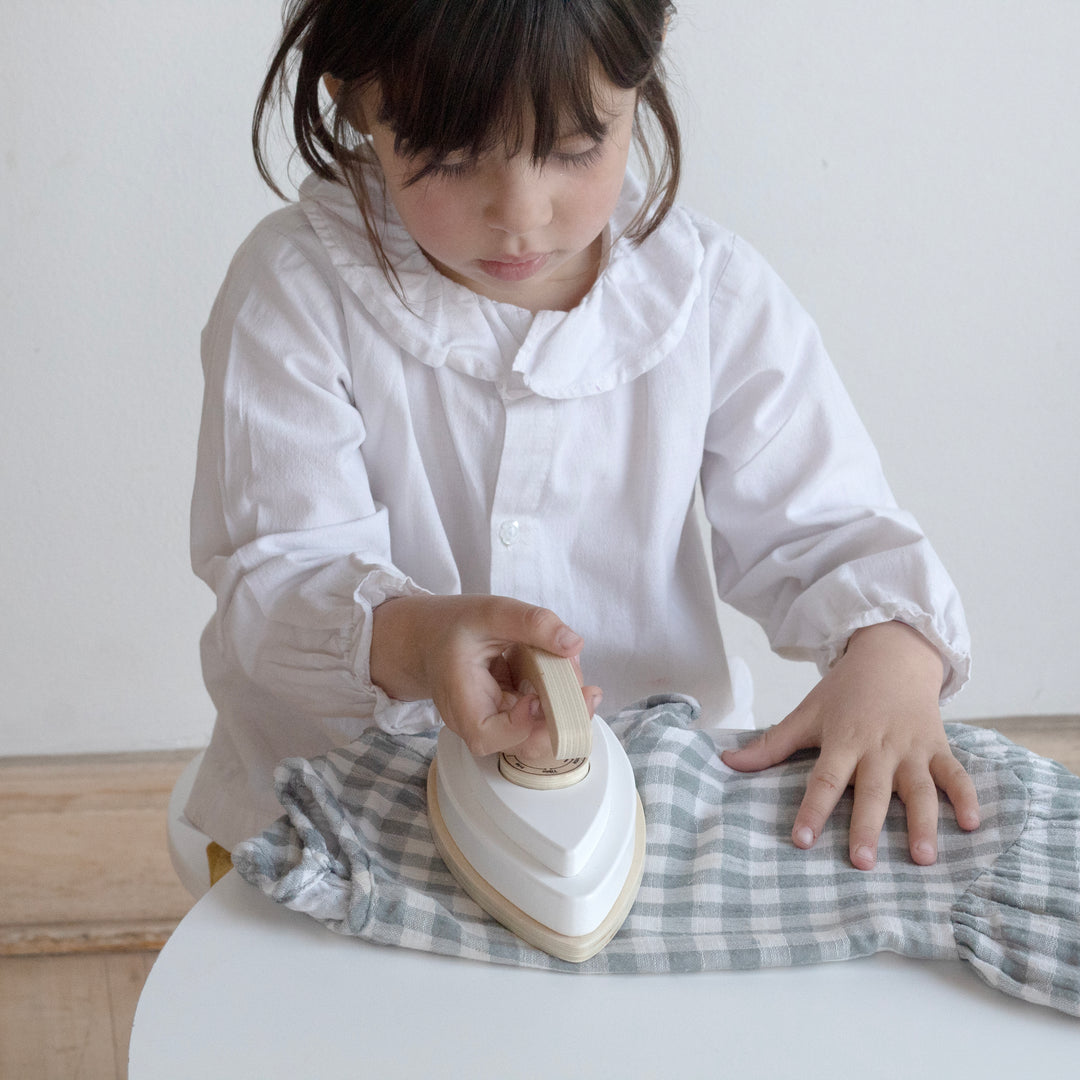Niña jugando con plancha de juguete de madera Montessori