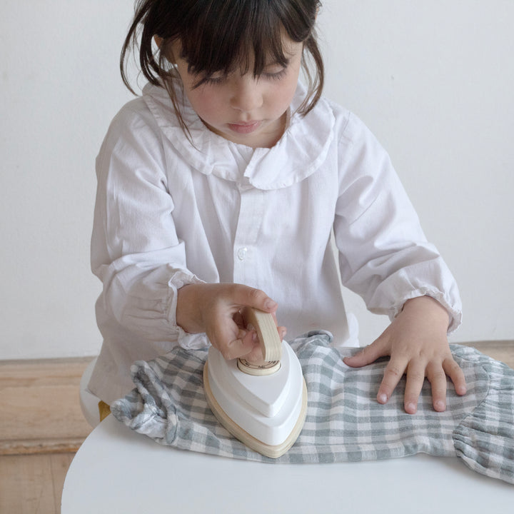 Niña jugando con plancha de juguete de madera Montessori