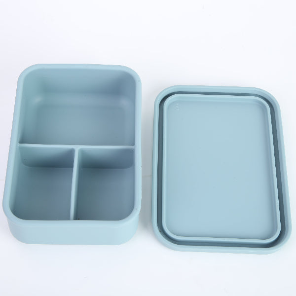 Lonchera de silicona celeste abierta con tres divisiones internas. Caja bento moderna para organizar la colación de niños