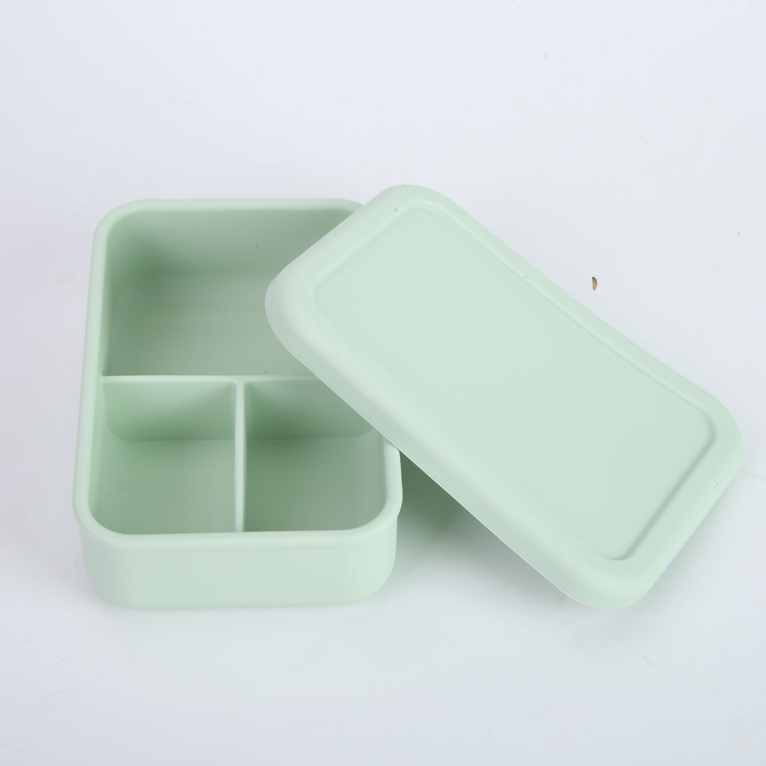 Lonchera de silicona verde menta abierta con tres divisiones internas. Caja bento moderna para organizar la colación de niños