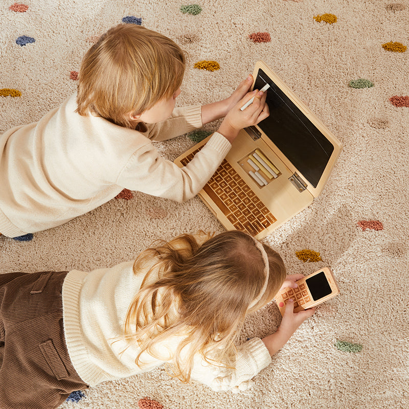 Notebook de juguete con pizarra y tizas junto a celular de madera, juguetes educativos Montessori para niños