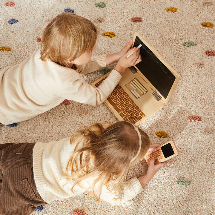 Notebook de juguete con pizarra y tizas junto a celular de madera, juguetes educativos Montessori para niños